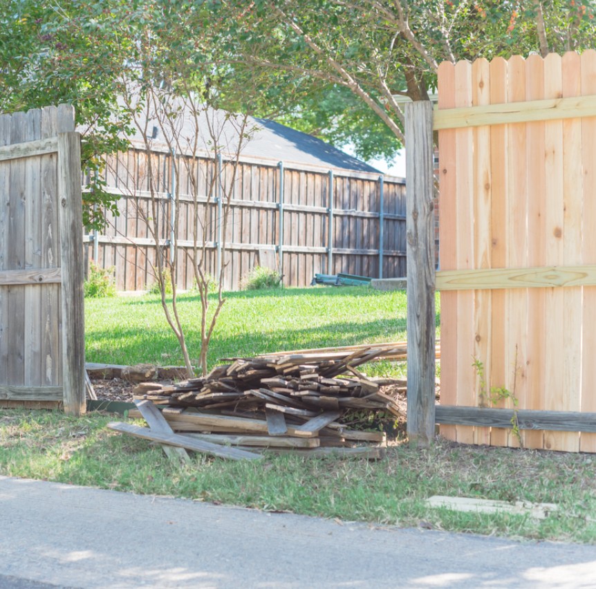 Replacing damaged fence panels in Edina, MN with new cedar pickets next to old weathered fence sections