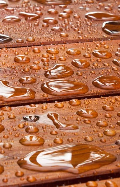 Close-up of water beading on a freshly sealed wood deck in Edina, MN
