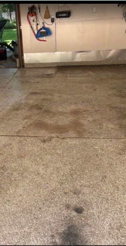 Oil stains on a concrete driveway before pressure washing in Edina, MN