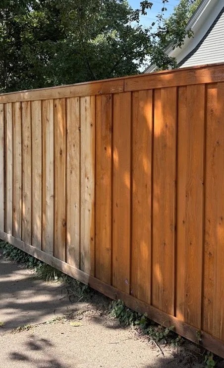 Before-and-after of a weathered fence freshly stained with a rich semi-transparent finish in Edina