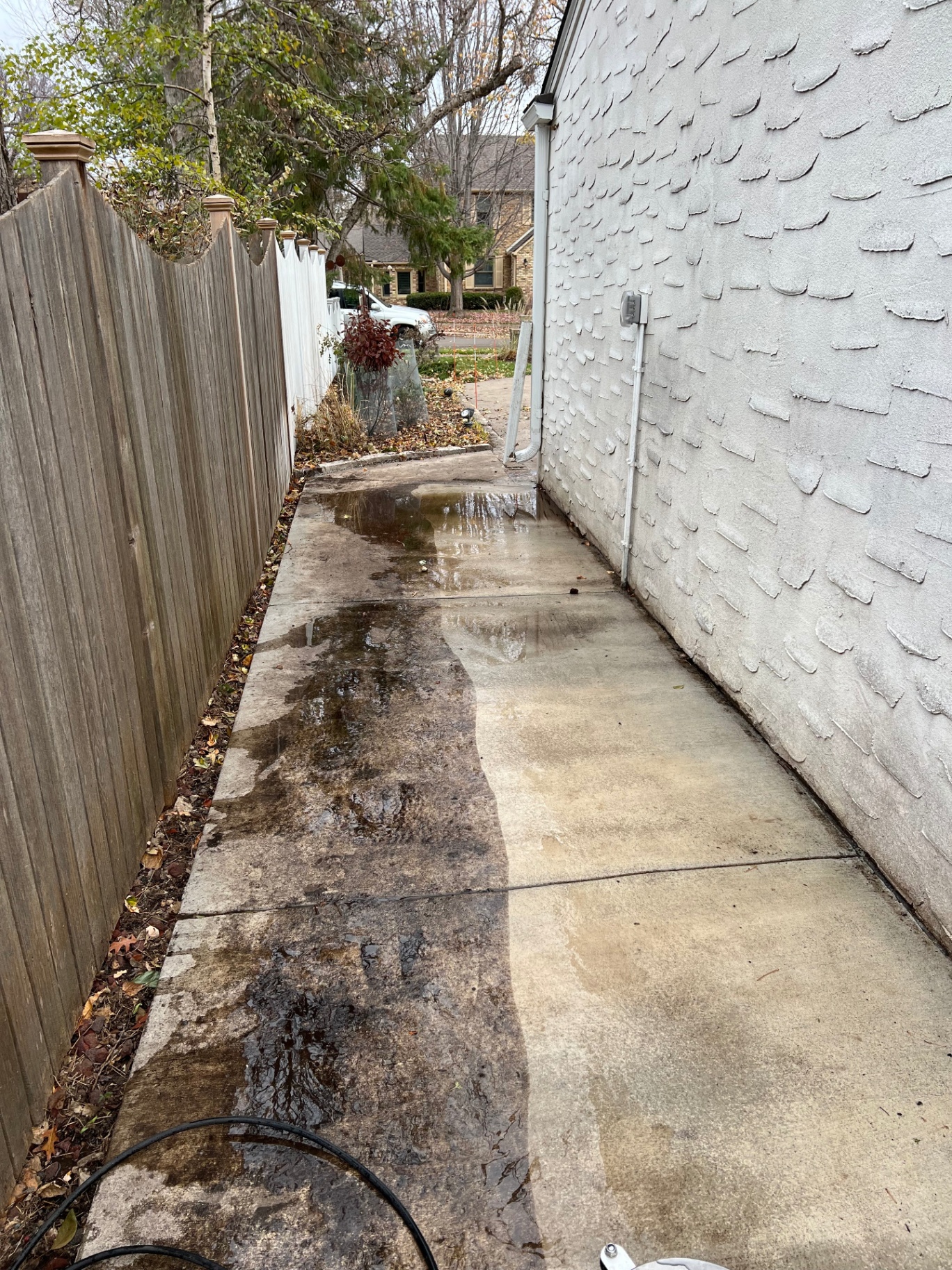 Grimey side walkway during pressure washing in Edina, MN showing clean and dirty concrete contrast